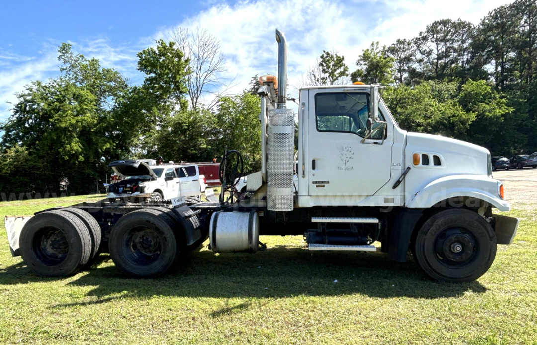 Truck side view of a white 2009 Sterling LT9500 cab and chassis with dual rear axles and vertical exhaust stack.