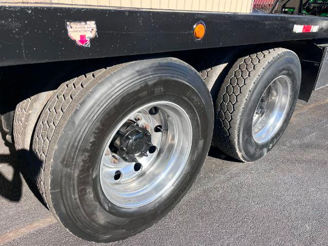 Truck trailer wheels showing dual rear axles with polished chrome rims and black tires on a rollback truck.
