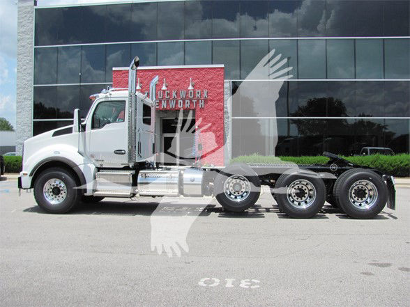 Kenworth T880 conventional daycab truck in front of a building showing stock number TJ219543LM.