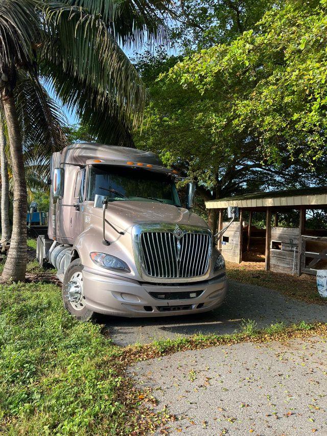 2009 International Prostar truck in driveway with palm trees, chrome grille, sleeper cab, side mirrors, and front bumper visible.