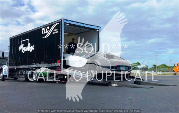 Peterbilt 337 tow truck with a black trailer inside a TLC container, door open, word 'SOLD' watermark across image.