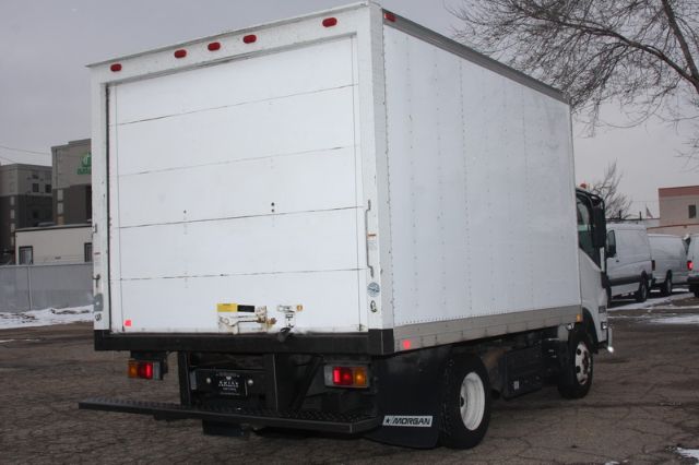 Isuzu NPR-HD box truck rear view with cargo box and taillights, white exterior, some snow on ground.