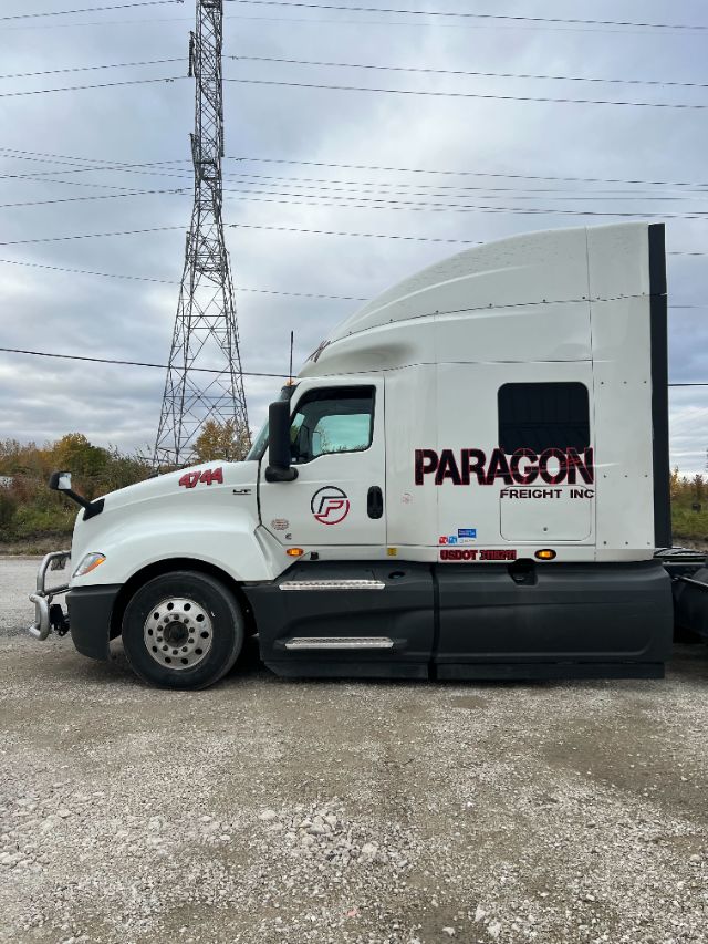 Truck side profile of a white 2019 International LT625 with Paragon Freight Inc. branding, sleeper cab, USDOT sticker and model badge visible.
