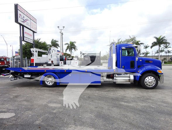 Blue 2022 Peterbilt 337 tow truck flatbed side view showing wheel, cab, and long flatbed.