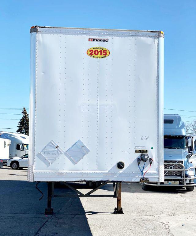 Manac 2015 dry van trailer rear view showing jump standards, reflective stickers, and electrical connections with a '2015' badge