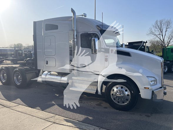 Truck cab and front section of a white 2020 Kenworth T880 tractor with sleeper, showing chrome bumper, large fuel tanks, and dual rear axles.