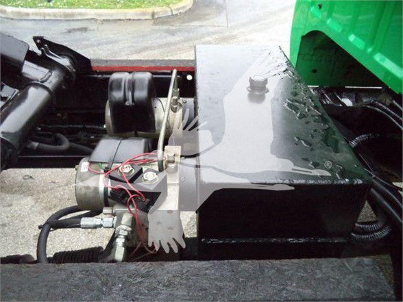 Engine bay area with control module and hydraulic lines; no legible brand text visible.