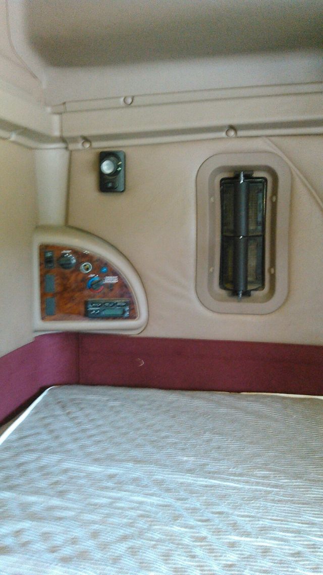 Interior sleeper area of a 2007 International 9900i showing control panel, window, and bed area.