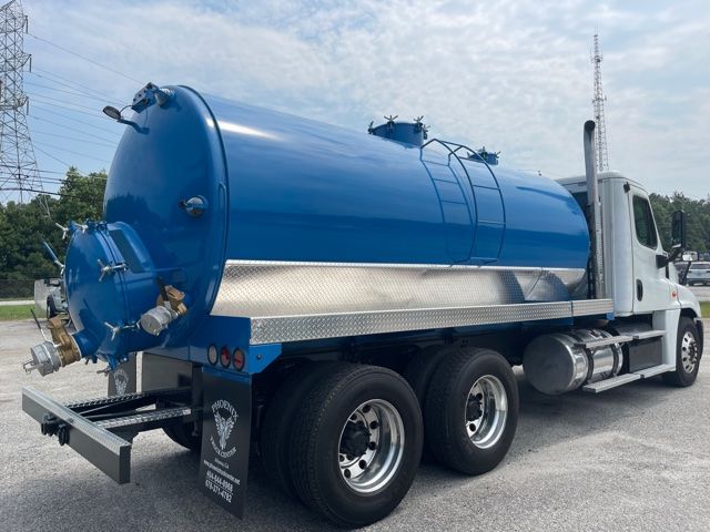 2013 Freightliner Cascadia vacuum/sewer service truck with large blue cylindrical tank mounted on day cab tractor, dual rear wheels, chrome diamond plate side railing, and hoses fittings.