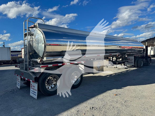 Heil Gal Tanker trailer with polished stainless steel cylindrical tank in a yard, rear view showing dual axles and rear ladder.