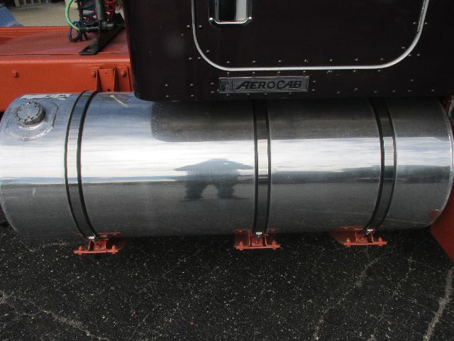 Conventional sleeper truck side showing cylindrical chrome fuel or storage tank with Aerocab badge and red mounting brackets.