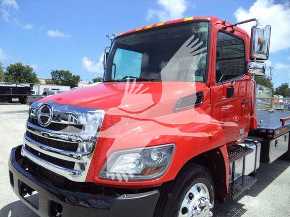 Red Hino 268A tow truck cab front view showing chrome grille and large side mirrors.