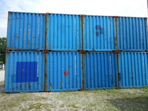 Used 20' wind weather tight containers stacked in two tiers, blue metal shipping containers with rust spots and markings.