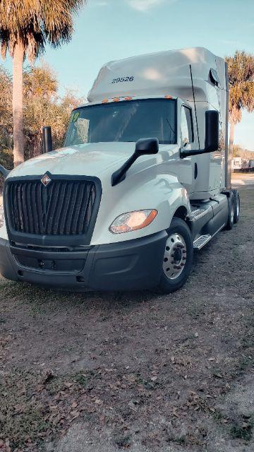 Truck front-left view of a white 2019 International conventional sleeper tractor with elevated sleeper cab, large grille, and dual rear wheels.