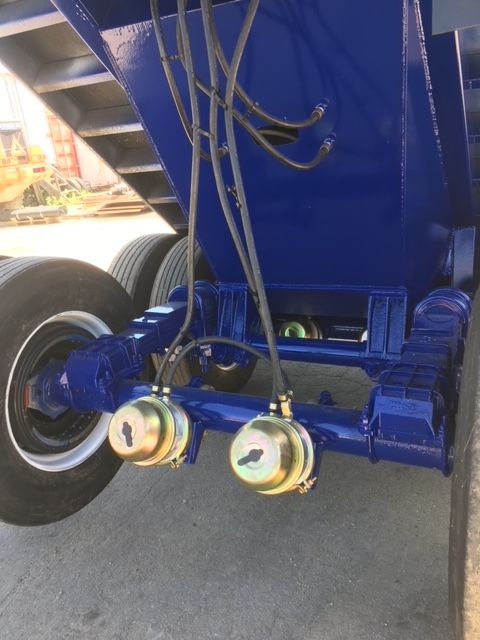 Blue utility 40 ft square dump trailer undercarriage showing axles, dual round access caps, hydraulic lines, and frame.