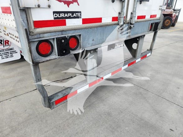 Rear view of a used 2021 Wabash trailer with Duraplate label, red circular lights, and red/white reflective bars.