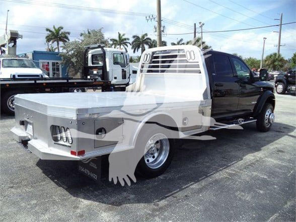 Ram 5500 flatbed service truck with black cab and white flatbed, side profile view.