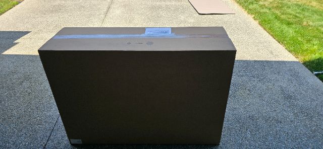 Boxed Volvo component with plain black exterior, placed on pavement outdoors.