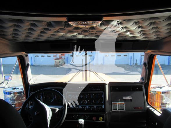 Kenworth W900L truck interior dashboard and steering wheel view from driver seat.
