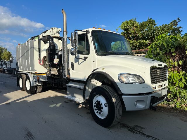 2014 Freightliner M2 vacuum truck in white with tank body and exhaust stack, front cab visible.