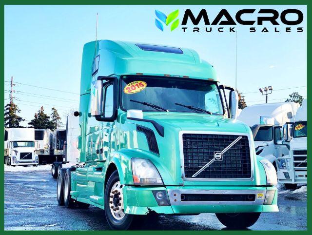 Volvo VNL 670 truck in teal color with MACRO TRUCK SALES logo in top right; 2015 sticker on windshield; conventional sleeper tractor.