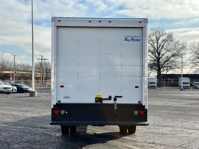 Ford F-550 box truck rear with Bay Bridge logo, taillights, rear bumper, and liftgate. Small stickers and hardware on doors.