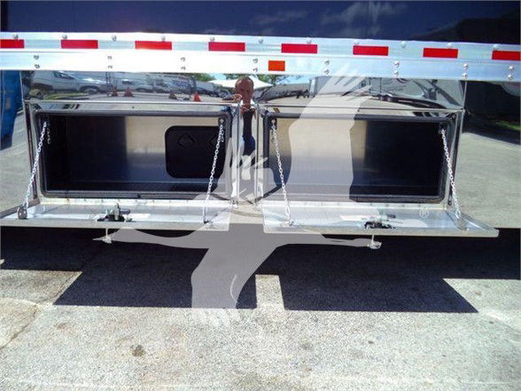 Open storage compartments at rear of a 2024 Mack MD6 tow truck. Dual tool/storage bays with chrome finishes and latches.