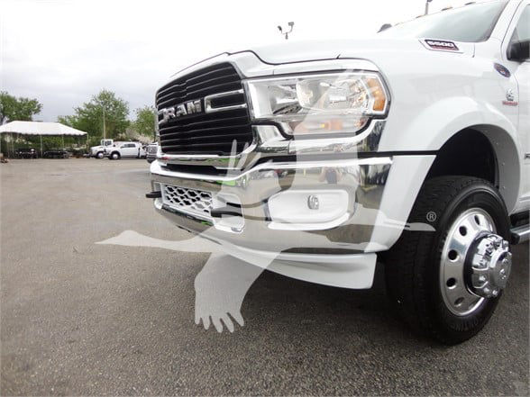 Ram 5500 HD SLT front left view showing chrome grille, bumper, and wheel with dual rear tire hub. Vehicle is white with Ram badge on grille.
