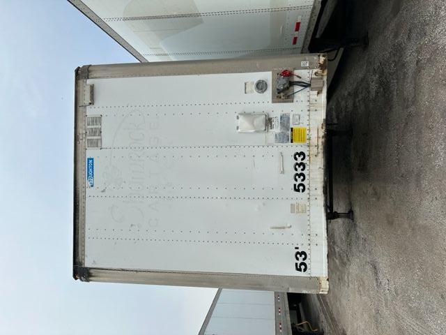 Rear view of a white 53' Stoughton dry van trailer with blue Stoughton badge at top center, trailer numbers 53' and 5333 printed at bottom left and center, various doors and equipment on right side.