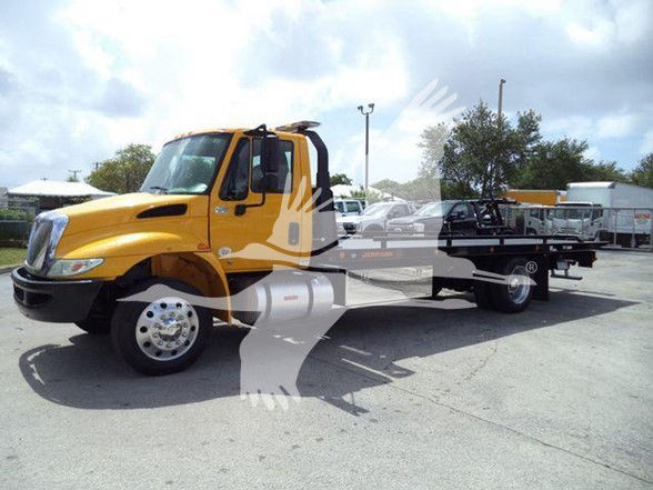 2019 International DURASTAR 4300 tow truck shown in a parking lot with a yellow cab and flatbed.