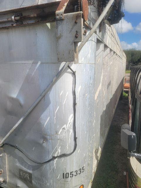 Trailer side wall with welded metal structure and wiring harness, serial number 105335 visible, weathered paint and scratches.