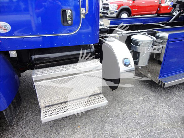 Truck step area of a blue Peterbilt 337 with diamond plate steps and fuel tank area visible.