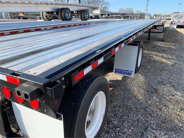 Flatbed trailer showing steel deck with Vanguard branding near the wheel wells.