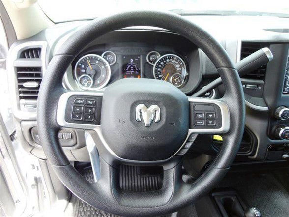 Ram steering wheel with Dodge RAM logo, instrument cluster with gauges, steering wheel controls, and center console visible.
