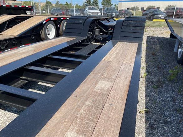 Lowboy trailer deck showing wooden floor planks and steel frame with hydraulic gooseneck area visible.