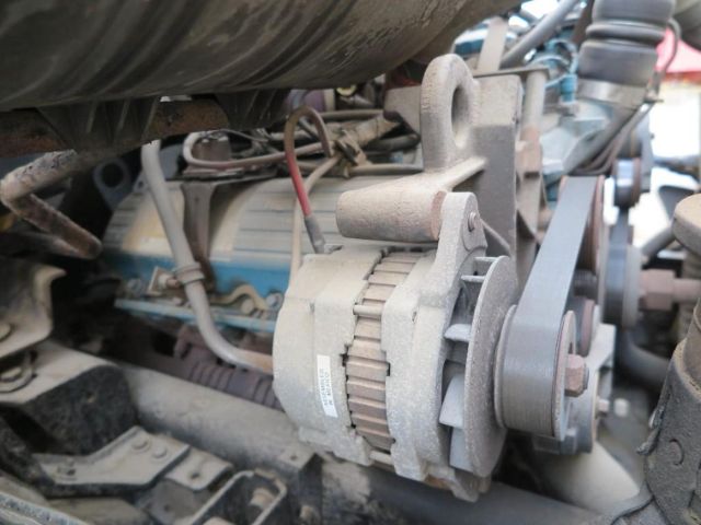Air-cooled alternator mounted in engine bay of International truck VT365 engine show with belts and pulley system.