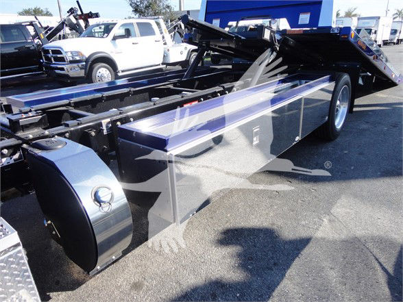 Peterbilt truck chassis with custom flatbed/tandem rear, chrome fuel tank and tool compartments visible.