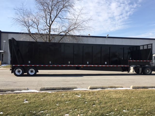 2002 Great Dane single drop crush car carrier trailer side view in black with white wheels and dual rear axles.