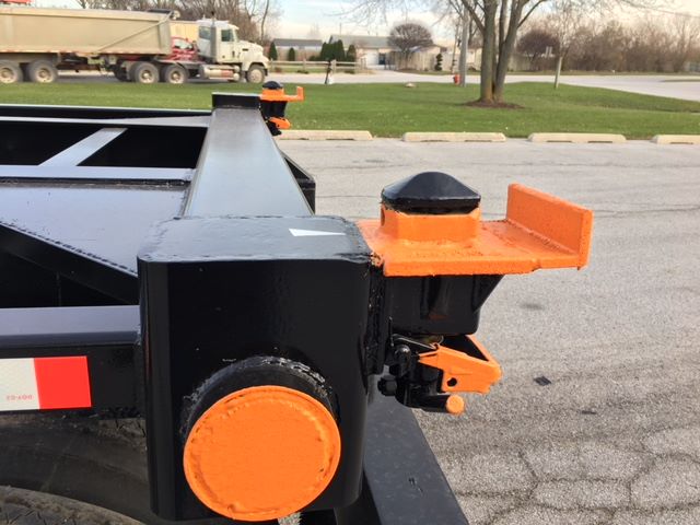 Trailer hitch area of a 2003 Wabash tipper trailer showing black metal frame and orange caps and components.