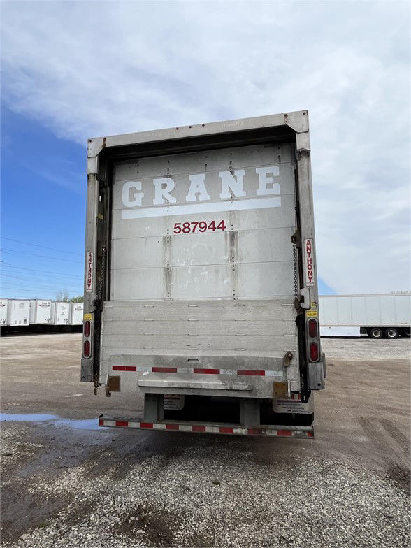 Great Dane DRY VAN trailer rear showing closed doors with Grane logo and stock number 587944. Vertical door posts have safety decals.
