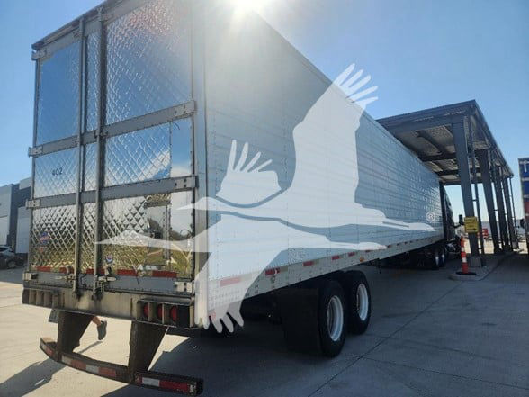 Trailer side and rear of a 2006 Utility 3000R refrigerated trailer with dual axles and metal ramp. Visible text includes signage on the back doors and reflective tape.