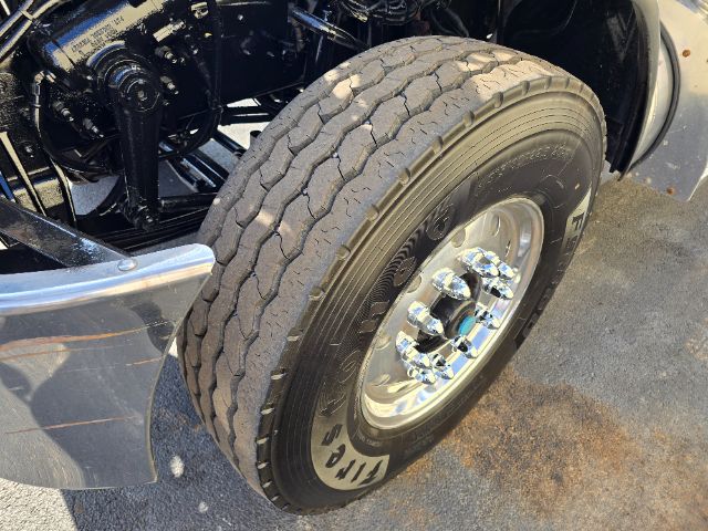 Peterbilt 348 wheel and front suspension with chrome rim and tire visible
