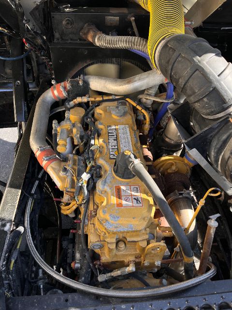 Caterpillar engine bay of a Kalmar Ottawa 30 yard truck showing yellow engine block, hoses, and intake manifold with labels.