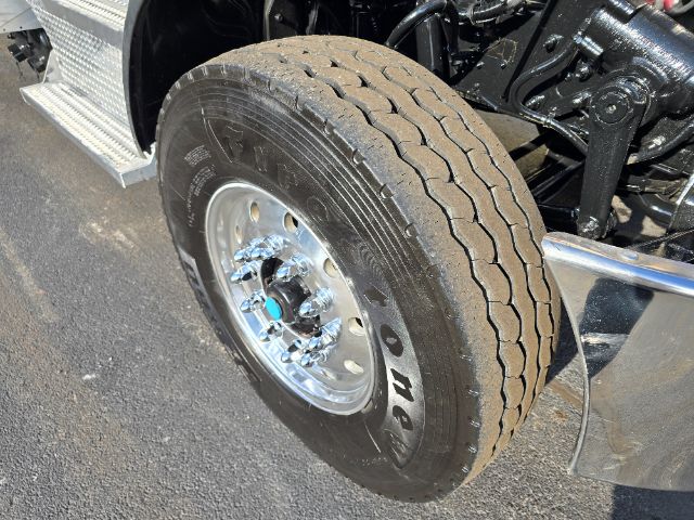 Peterbilt 348 front wheel and suspension showing chrome wheel, tire, and part of the chassis.