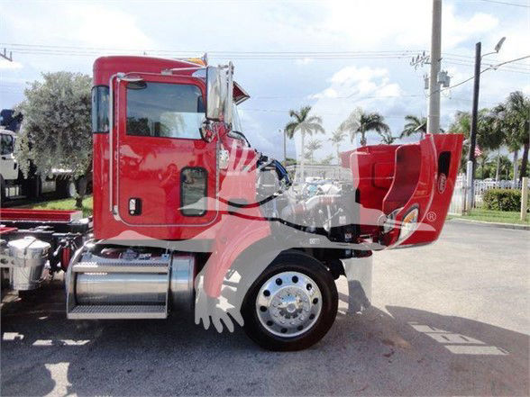 Peterbilt 337 truck cab and chassis in red, side view showing fuel tanks and front wheel, 2022 model, new with no trailer attached.