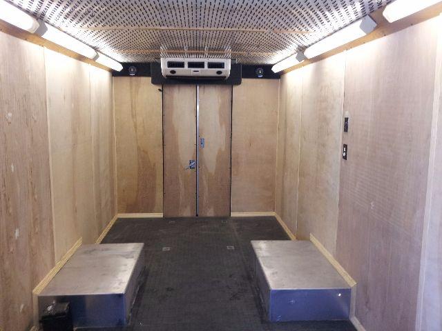 Interior cargo area of a 2005 Workhorse P42 step van showing wooden walls, a raised rear floor with two blue steps, and an HVAC unit at the front.