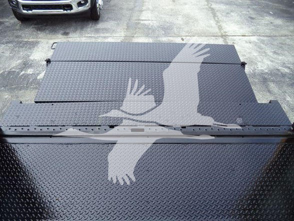 Trucks listing image showing a diamond plate flatbed with a large gray bird logo overlay. The photo focuses on the bed area of a box truck.