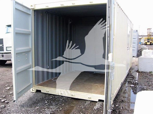 Container trailer with open door showing empty interior; watermark of a flying bird graphic across the space.
