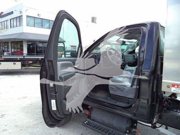 Truck cab interior with open driver door showing steering wheel and seat in Silverado 6500HD crew cab chassis.