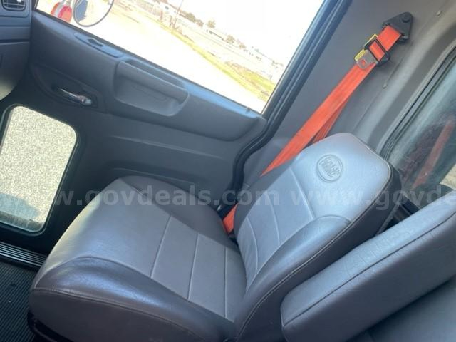 Peterbilt 365 truck interior with grey leather seat and orange seat belt, driver’s door panel visible.
